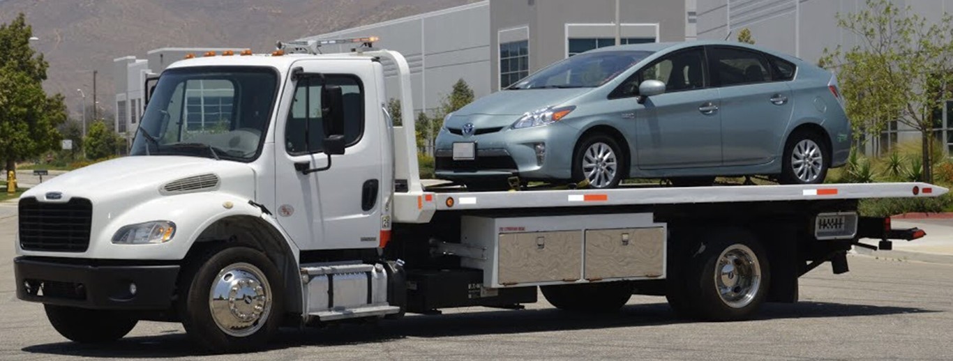 Professional flatbed towing service with car loaded on tow truck in La Habra, CA